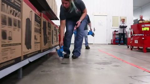 mover placing a skate roller under a loaded store-fixture shelf